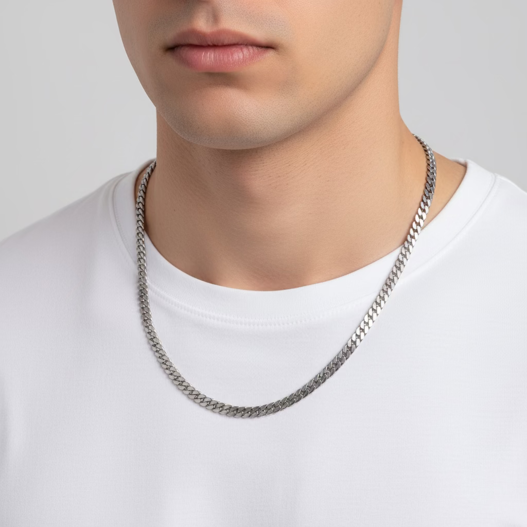 Man wearing a silver curb chain necklace with a white crew neck shirt