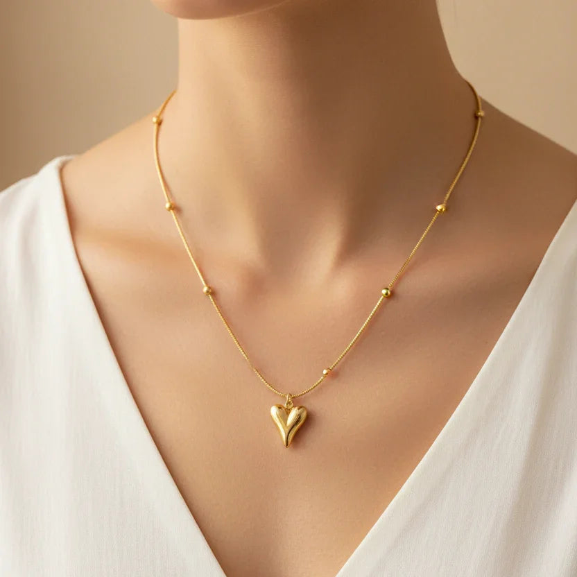 Woman wearing a gold heart pendant necklace with bead accents, anti-tarnish jewelry