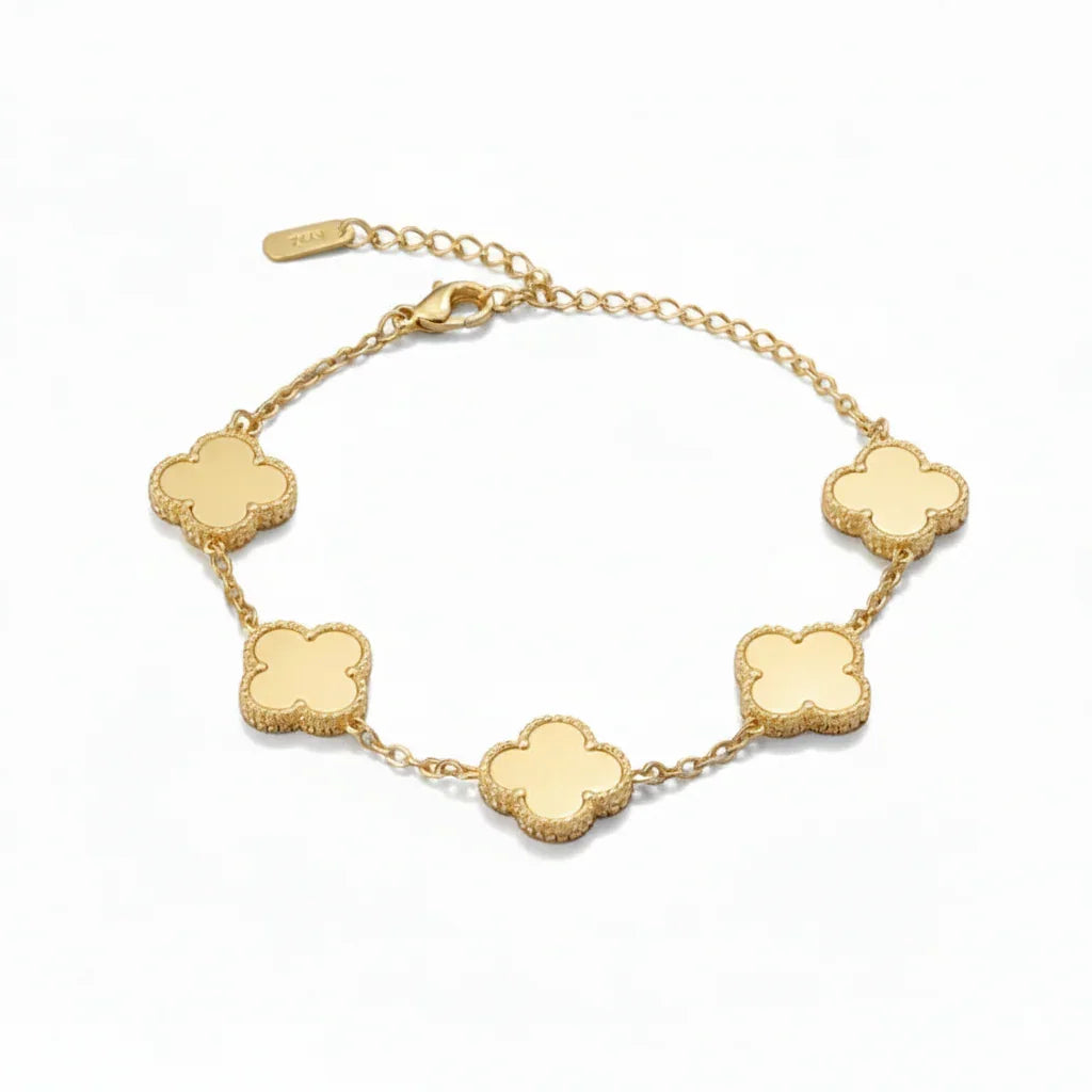 Gold bracelet with five four-leaf clover charms on a delicate chain on white background