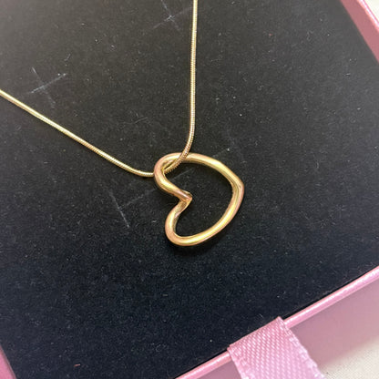 Gold abstract heart pendant necklace on black velvet jewelry box