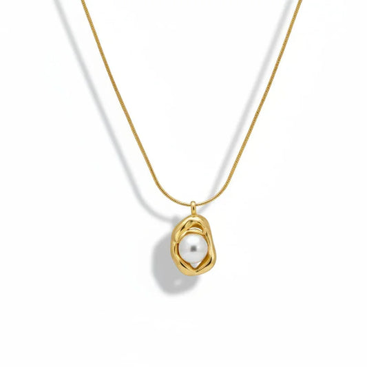 Gold chain necklace with abstract pendant holding a single pearl on white background
