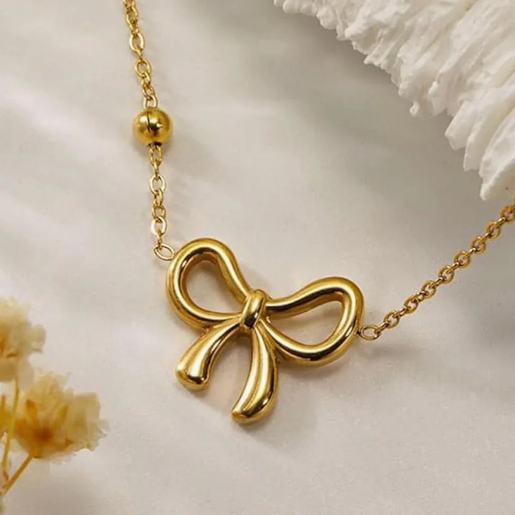 Gold bow pendant necklace on gold chain, elegant women's anti-tarnish jewelry.